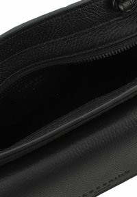 Czarna skórzana kopertówka z fakturowanym wykończeniem, z zamkiem błyskawicznym i gładką podszewką. Minimalistyczny design, brak widocznych akcentów metalowych.