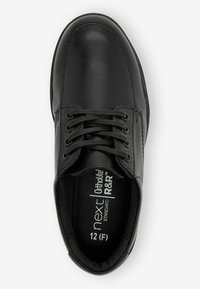 Chaussure en cuir noir avec un bout rond, un design à lacets et une semelle intérieure marquée. Présente des accents cousus et une texture lisse. Taille 12 (F).