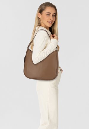 Braune Leder-Schultertasche mit glatter Textur, geschwungener Form, verstellbarem Tragegurt und einem dezenten Logo am Boden.