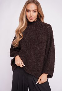 Dark brown oversized sweater with a textured, fuzzy surface and a high neckline, featuring wide sleeves and a loose fit.