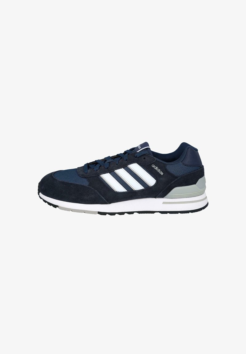 Zapatilla deportiva de color azul marino con parte superior de serraje y malla, diseño de tres rayas blancas, cuello acolchado y una suela de goma duradera.