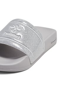 Zilveren glinsterende slippers met een brede band met een wit logo en rand, een gestructureerd voetbed en een lichtgewicht zool.