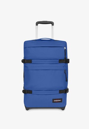 Maleta azul de lado blando con correas negras, dos bolsillos frontales con cremallera, asa extensible negra y logo de Eastpak en la parte inferior derecha.
