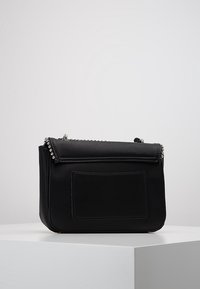 Borsa a mano in pelle nera con finitura testurizzata, dotata di una patta frontale, dettagli in metallo argentato e una tasca posteriore rettangolare.