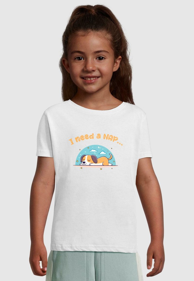 Hvid bomulds t-shirt med en tegneseriehund, der sover under teksten "Jeg har brug for en lur..." med en blå og sky-mønstret baggrund.