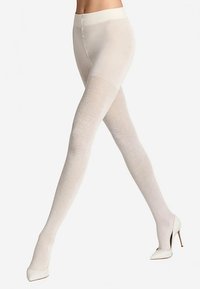 Witte gestructureerde panty's met een visgraatmotief en een effen bovenstuk, gecombineerd met witte hoge hakken.