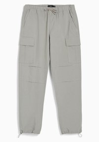 Světle šedé pracovní kalhoty s elastickým pasem a stahovacím provázkem, se dvěma bočními kapsami a zúženými manžetami s nastavitelnými šňůrkami.