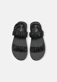 Black flip-flops with dual ruched bands made of glossy fabric, featuring a flat sole and textured footbed for comfort.