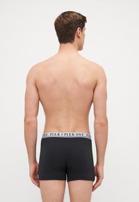 Schwarze Herren-Boxershorts aus einem weichen Material mit einem weißen Logo-Bund. Das Design ist enganliegend und bietet eine angenehme Passform am Körper.