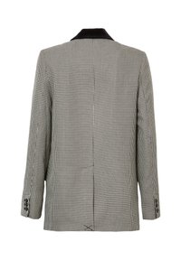 Blazer houndstooth in bianco e nero con colletto in velluto nero, maniche lunghe, spacco posteriore e dettagli in bottoni sui polsini.