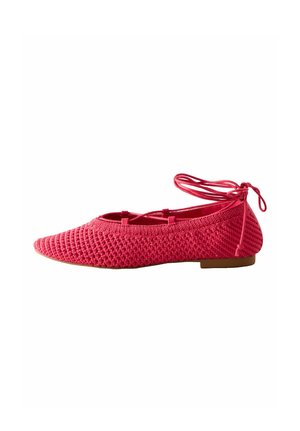 Platte roze gebreide balletschoen met enkelwikkelbandjes en een lage bruine zool, afgebeeld in profiel naar links.