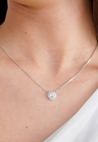 Silberne Kettenanhänger mit einem herzförmigen Pendant, das mit klaren Edelsteinen verziert ist, die Licht reflektieren und filigrane Details zur Schau stellen.