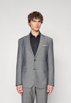 Gray textured suit jacket featuring a single button closure, notched lapels, and two front pockets, worn over a black shirt.
