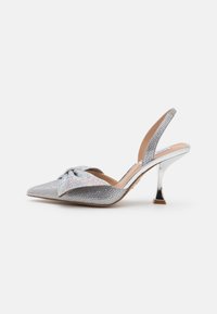Silver slingback high heels with a pointed toe, covered in rhinestones, featuring a bow detail and a metallic stiletto heel.