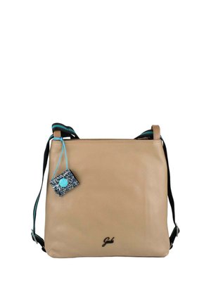 Borsa a tracolla in pelle beige con tracolla regolabile nera e turchese e piccola targhetta blu scintillante appesa all'angolo in alto a sinistra.