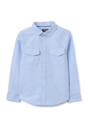 Camisa de manga larga de color azul claro, hecha de un tejido suave, con cuello abotonado, dos bolsillos en el pecho y botones blancos.