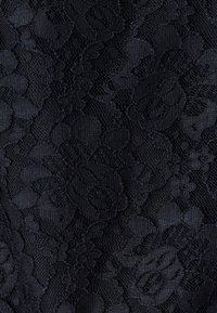 Melna mežģīņu auduma ar ziedu rakstu un dažādām faktūrām. Sarežģītais dizains izceļ paceltus ziedu motīvus caurspīdīgā fonā.