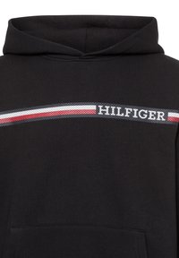 Sudadera con capucha negra, hecha de algodón, con un bolsillo frontal. El logo centrado presenta un patrón de rayas texturadas en rojo, blanco y azul.