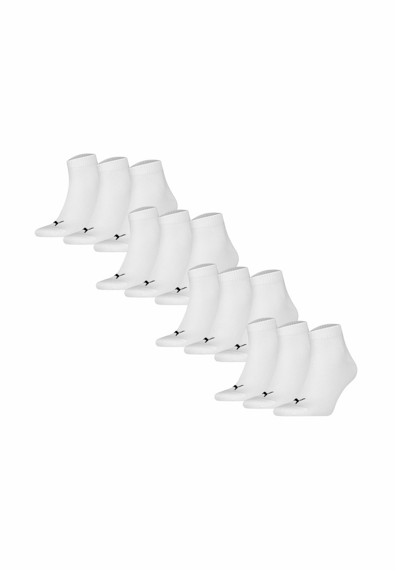 Vita ankelsockor med en svart logotyp, tillverkade av elastiskt material, 12 par arrangerade i en skiftad rad för visning.