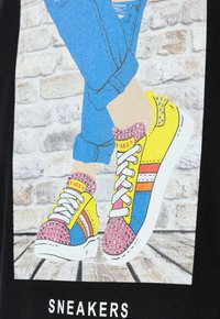 Farverige sneakers med pink, gul og blå sektioner, pyntet med rhinsten, med hvide snørebånd og stribede accenter.