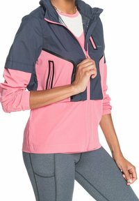Giacca leggera in blu navy e rosa, dotata di zip frontale, polsini elastici e numerose tasche con accenti neri a contrasto.
