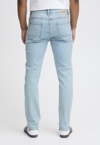 Ljusblå jeans med slim fit, fem fickor och kontrasterande sömmar. Har subtila detaljer på bakfickorna och en märkesbyxa.