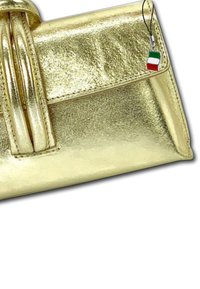 Gouden metallic handtas met een gestructureerde vorm, voorzien van een gevouwen ontwerp en twee handvatten aan de bovenkant, plus een kleine Italiaanse vlag charm.