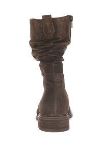 Botte de cheville en daim marron avec un design fléchi, fermeture à glissière et talon empilé. Elle présente une texture douce et des coutures minimalistes.