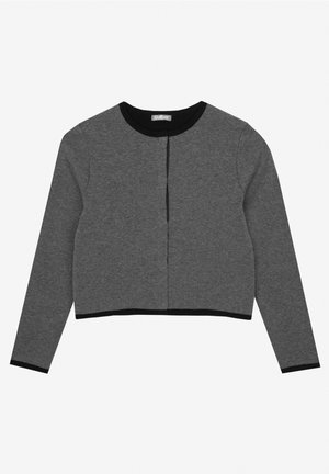 Cardigan cropped gris en tissu lisse, avec des manches longues et une bordure noire le long de l'encolure et de l'ourlet. Fermeture à l'avant sans fermetures visibles.