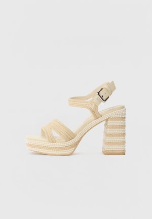 Beige hoge hakken sandalen met bandjes, voorzien van een textiele bovenkant, een verstelbare gesp en een stevige, gestreepte blokhak.