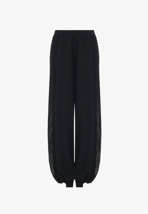 Pantalones anchos negros con paneles laterales de malla texturizada y puños y cinturilla elásticos.