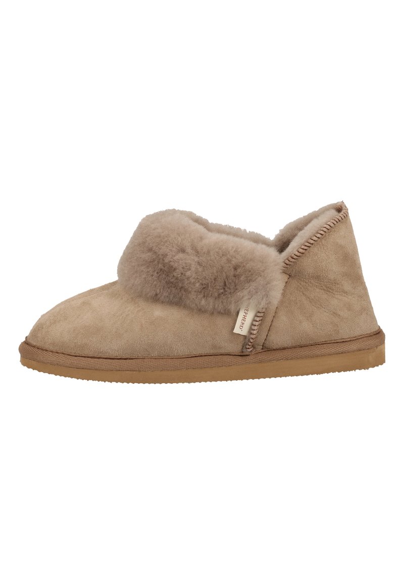 Pantoufles en suède beige avec un doux bord en fourrure et une semelle en caoutchouc flexible. Comprend des détails de couture sur les bords et une étiquette sur le côté.