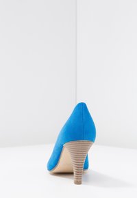 Blue suede high heel shoe with a pointed toe and textured beige heel. The design features a smooth finish and a slim silhouette.