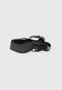 Black heeled sandal with smooth leather material, adjustable strap, and decorative gold accents on strap. Thick, ribbed black sole.