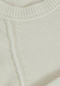 Kremna pletena pulover s okroglim izrezom, ki se ponaša z teksturiranim vzorcem in rebrastimi robovi. Mehka tkanina s subtilnim, raznolikim tkanjem.