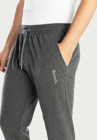 Grijze sweatpants van zacht stof, met een verstelbare tailleband en zijzakken. Bevat het "Bench." logo in lichtgrijs op het been.