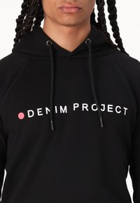Zwarte hoodie met een trekkoord, met een witte tekstlogo "DENIM PROJECT" en een rode stipaccent op de borst. Soepele textuur.
