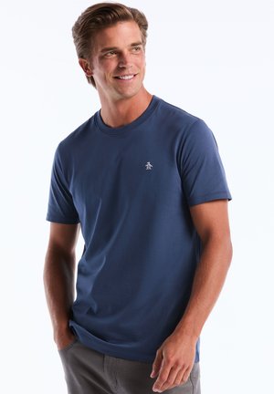 Navyblaue Baumwoll-T-Shirt, Rundhalsausschnitt, kurze Ärmel, mit einem kleinen weißen Pinguin-Logo auf der linken Brust, glatte Textur.