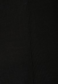 Zwarte ribstof met een gestructureerd oppervlak, gekenmerkt door verticale lijnen. Het materiaal lijkt rekbaar en zacht, met een lichte glans.