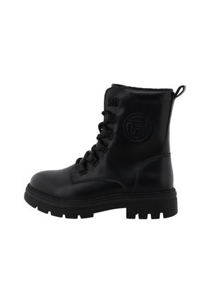 Black leather lace-up combat boot with thick rubber sole and round toe, featuring embossed circular logo on side and heel pull tab.