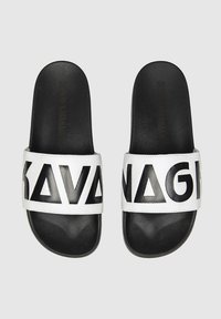 Chanclas en blanco y negro con una tira ancha que presenta letras negras en negrita y diseños geométricos sobre un fondo blanco liso.
