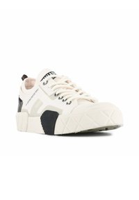 White sneaker with textured rubber sole, mesh upper, and black accents. Features lace-up design and logo on the tongue and side.