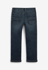 Vaqueros de mezclilla azul oscuro con un corte estándar, puños enrollados, dos bolsillos traseros y detalles de costura sutiles. Textura suave y diseño clásico.
