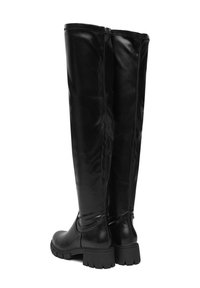 Cizme negre până la coapse, realizate dintr-o piele ecologică lucioasă, având o talpă groasă, fermoar la spate și o textură netedă, fără ornamente vizibile.