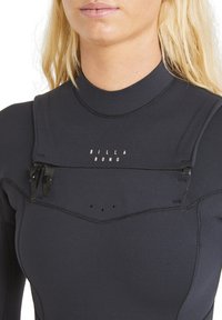 Black wetsuit with short zipper and adjustable straps at the chest. Features flat seams and a textured neck area. Logo "BILLA BONG" on front.