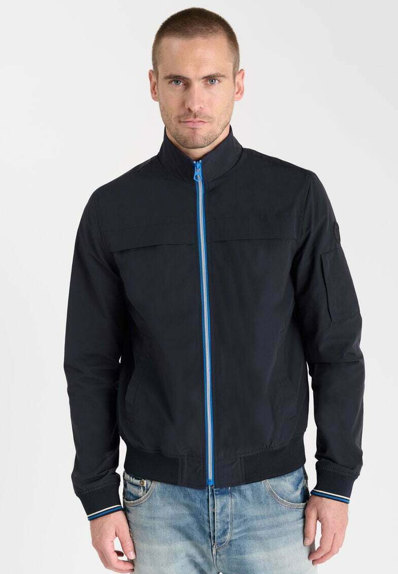 Veste bomber bleu foncé avec un col haut, fermeture éclair à l'avant avec un liseré bleu, et poignets côtelés. Stylée avec un design épuré et minimaliste.