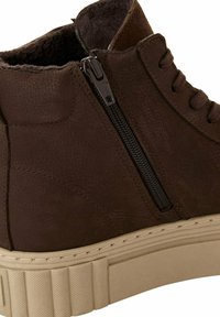 Bottine en cuir marron avec finition texturée, semelle en caoutchouc beige, fermeture éclair sur le côté et détail de lacets.
