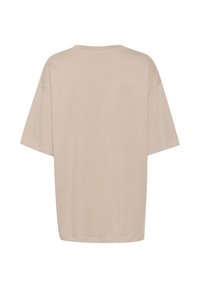 Beige oversized t-paita, lyhyet hihat, pyöreä pääntie, valmistettu pehmeästä puuvillasta, jossa on sileä rakenne ilman näkyviä logoja tai kuvioita.