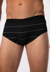 Zwarte katoenen boxershort met witte horizontale strepen. Elastische tailleband met merkl logo. Fitted vorm die comfort en ondersteuning verbetert.