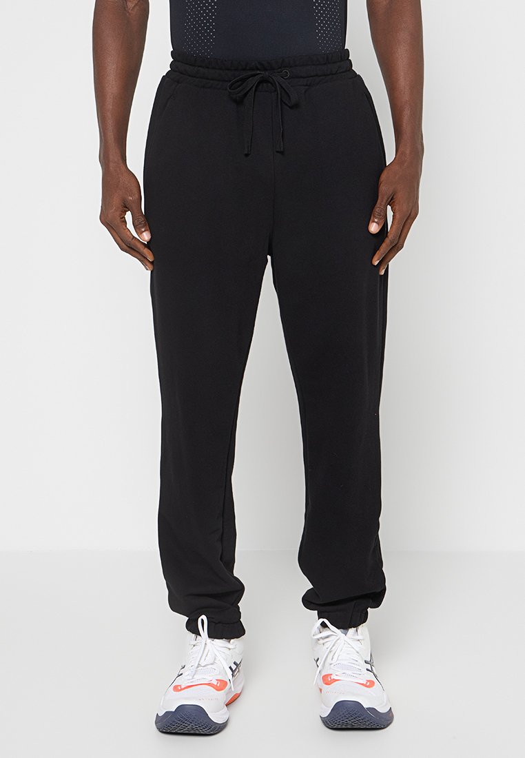 Czarne sportowe spodnie dresowe z miękkiego, elastycznego materiału, z regulowanym paskiem w talii, bocznymi kieszeniami i zwężanymi nogawkami.